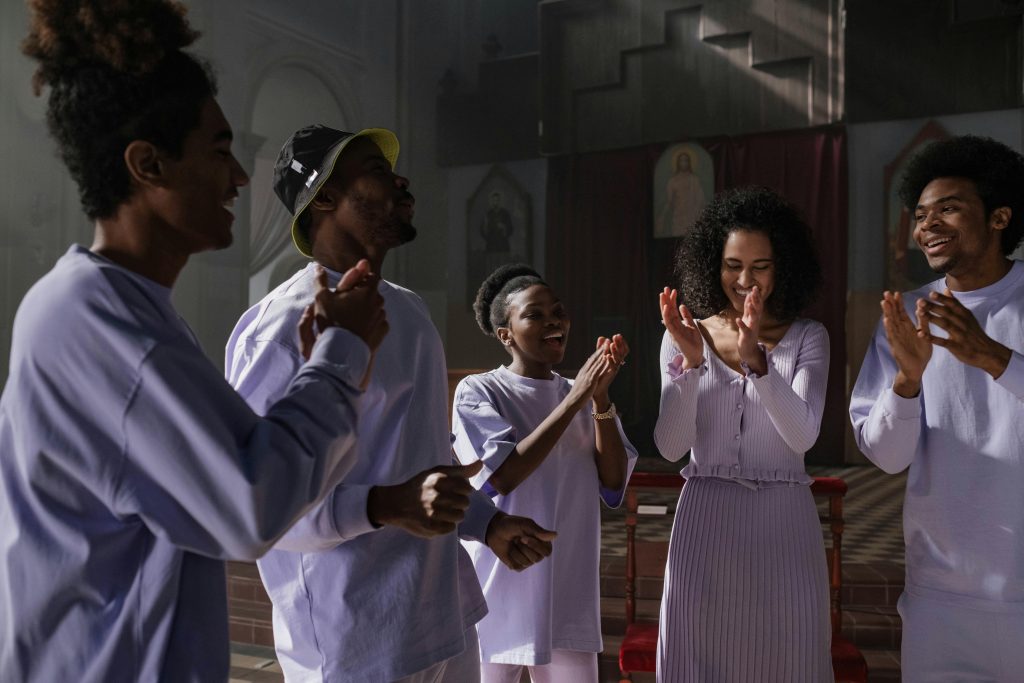 A diverse group of men and women singing joyfully in a church setting, expressing unity and harmony.